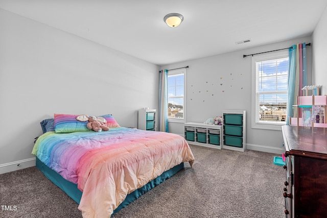 carpeted bedroom featuring baseboards, multiple windows, and visible vents