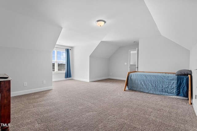 carpeted bedroom with vaulted ceiling and baseboards