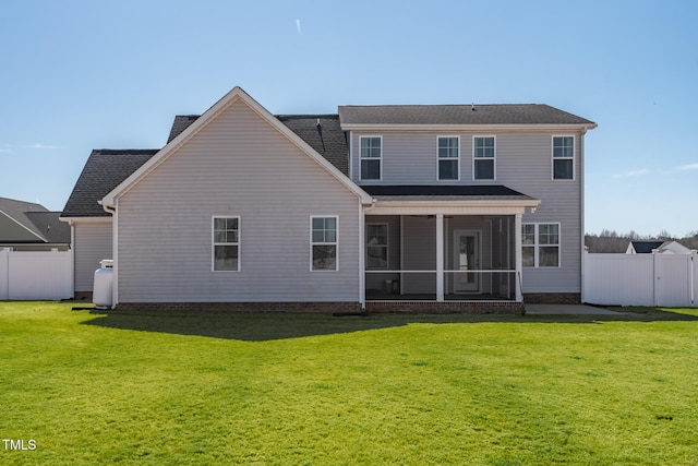 rear view of house featuring a lawn, fence, and a sunroom