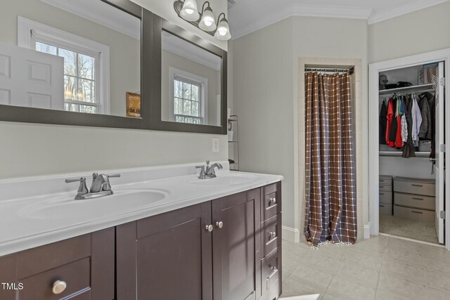 full bath with double vanity, ornamental molding, tile patterned floors, and a sink