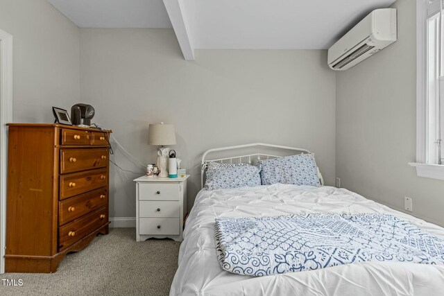 bedroom featuring beam ceiling, a wall mounted AC, and carpet floors