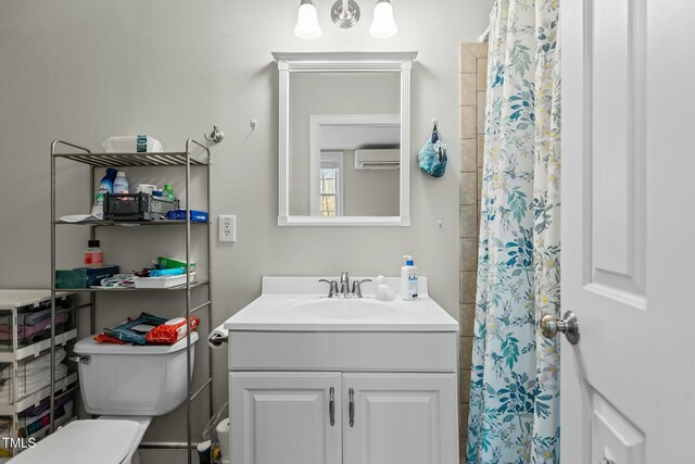 full bathroom featuring vanity, an AC wall unit, toilet, and a shower with shower curtain