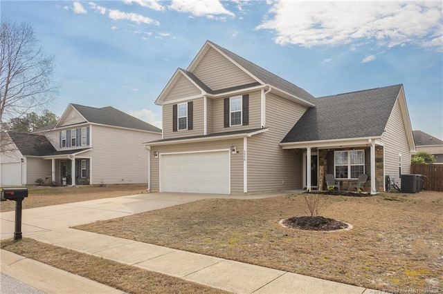 view of front of house featuring concrete driveway, central AC, and an attached garage