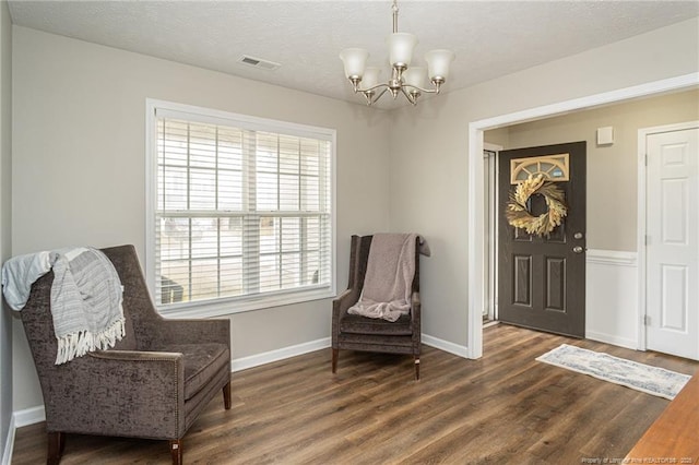 sitting room featuring visible vents, baseboards, and wood finished floors