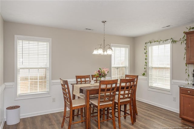 dining room featuring baseboards, dark wood finished floors, visible vents, and an inviting chandelier