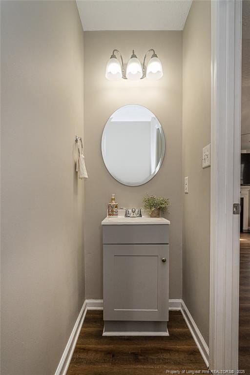 bathroom featuring wood finished floors, vanity, and baseboards