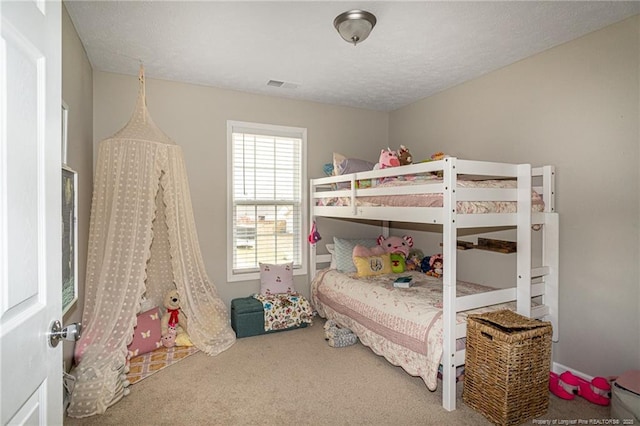 carpeted bedroom with visible vents and a textured ceiling