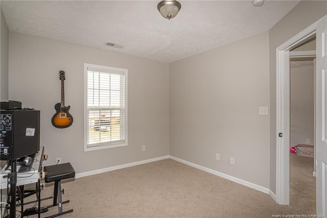 carpeted office with visible vents, a textured ceiling, and baseboards