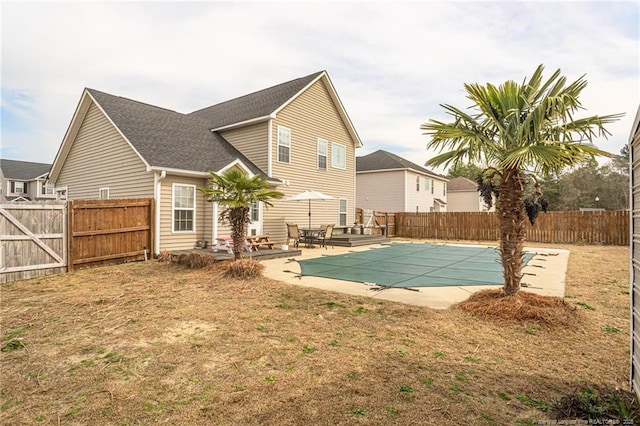 back of house with a patio, a fenced backyard, and a fenced in pool