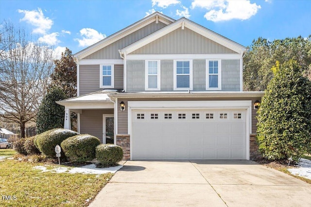 view of front of home featuring a garage, stone siding, and driveway