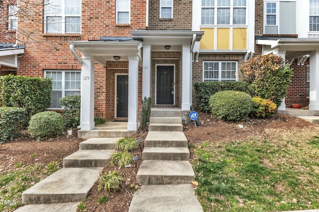 doorway to property featuring brick siding