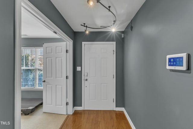 foyer with track lighting, baseboards, and wood finished floors