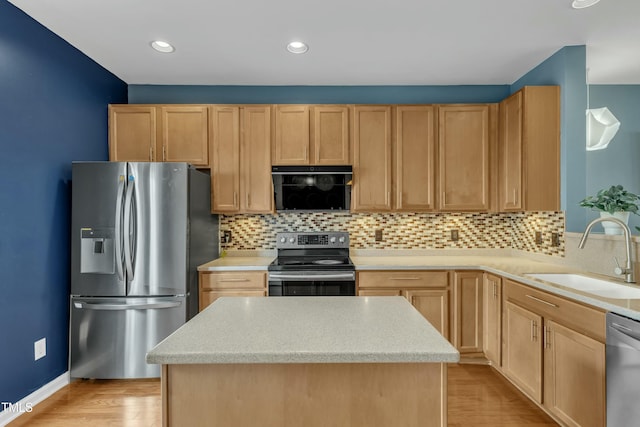 kitchen featuring tasteful backsplash, appliances with stainless steel finishes, a sink, and light brown cabinetry