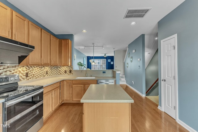 kitchen featuring under cabinet range hood, a sink, visible vents, appliances with stainless steel finishes, and tasteful backsplash