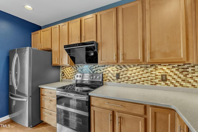 kitchen with stainless steel appliances, exhaust hood, light countertops, and decorative backsplash