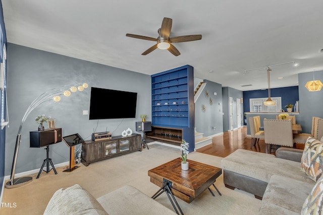 living area with ceiling fan and baseboards