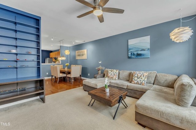 carpeted living area with rail lighting and ceiling fan