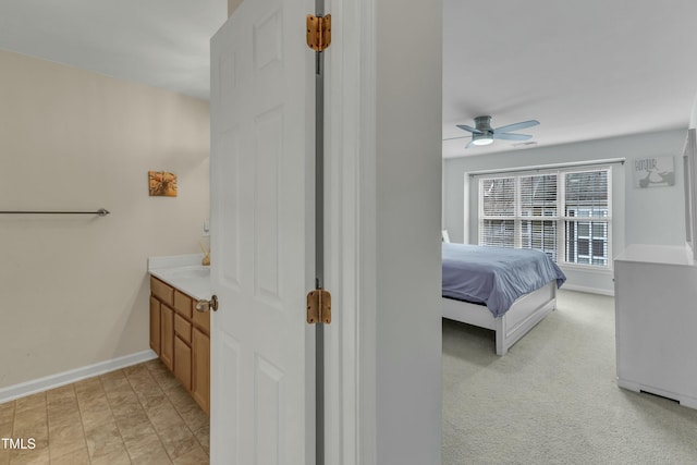 bedroom featuring ceiling fan, light colored carpet, and baseboards