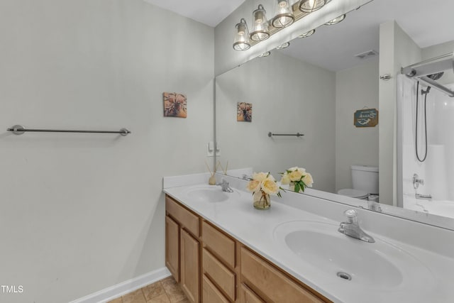 bathroom with toilet, double vanity, visible vents, and a sink