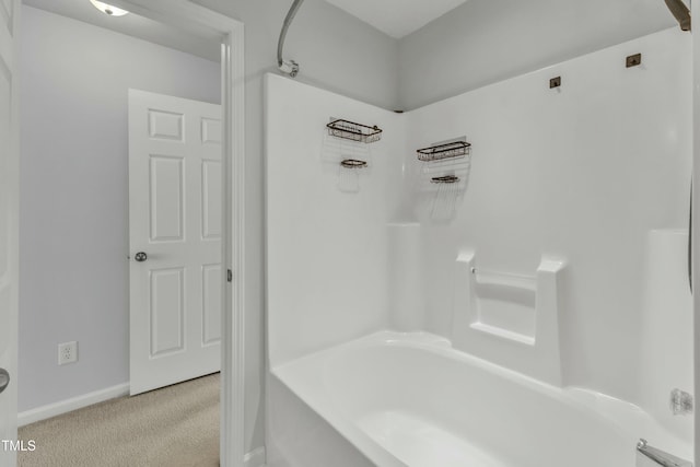 bathroom with bathtub / shower combination and baseboards