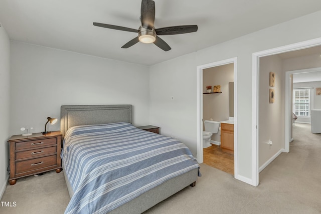 bedroom featuring light carpet, ensuite bath, baseboards, and ceiling fan