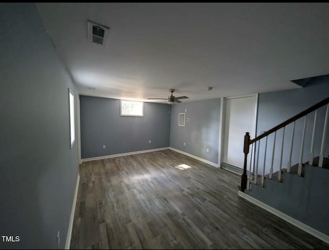 empty room featuring visible vents, stairway, a ceiling fan, wood finished floors, and baseboards