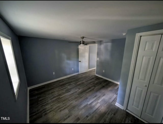 spare room with dark wood-style floors and baseboards