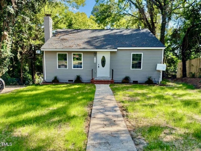 view of front of home with a front lawn, crawl space, a chimney, and fence