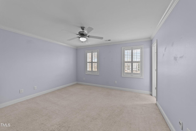 carpeted empty room with visible vents, crown molding, baseboards, and ceiling fan