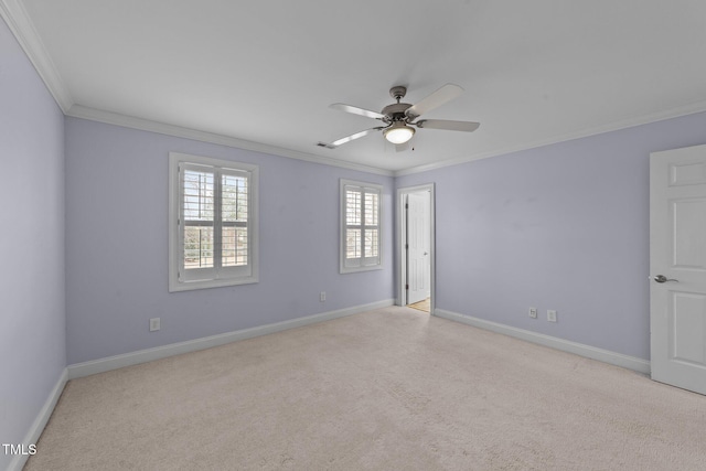 empty room with carpet, visible vents, ornamental molding, and baseboards