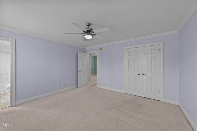 unfurnished bedroom featuring ensuite bathroom, baseboards, a closet, carpet, and crown molding