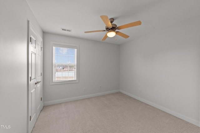 carpeted empty room with visible vents, ceiling fan, and baseboards