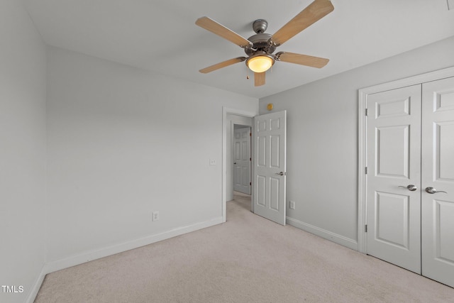 unfurnished bedroom featuring carpet floors, a closet, ceiling fan, and baseboards