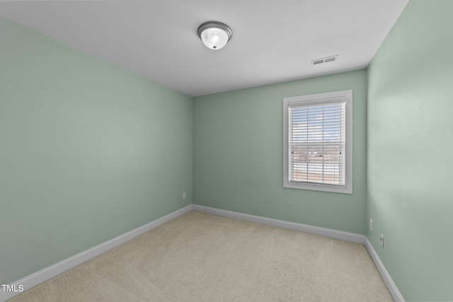 unfurnished room with baseboards, visible vents, and light colored carpet