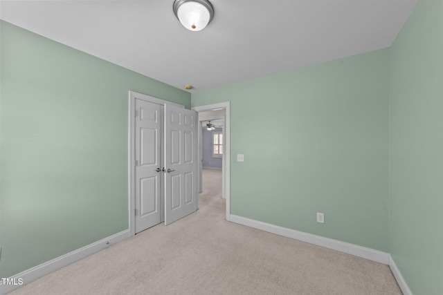 unfurnished bedroom featuring carpet floors, a closet, and baseboards