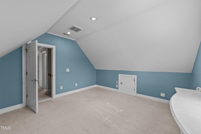 additional living space featuring lofted ceiling, visible vents, and baseboards