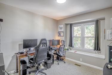 carpeted office space featuring visible vents and baseboards