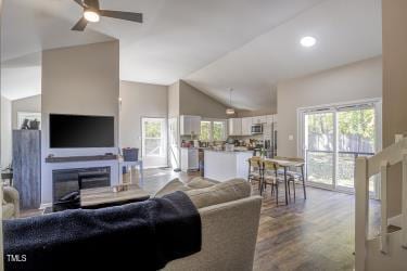 living room featuring a ceiling fan, lofted ceiling, recessed lighting, and wood finished floors