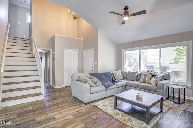 living room with baseboards, a ceiling fan, wood finished floors, stairs, and high vaulted ceiling