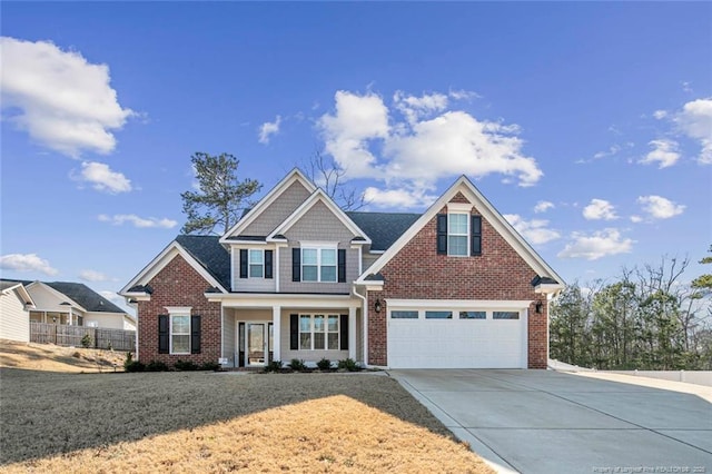 craftsman-style home featuring brick siding, concrete driveway, fence, a garage, and a front lawn