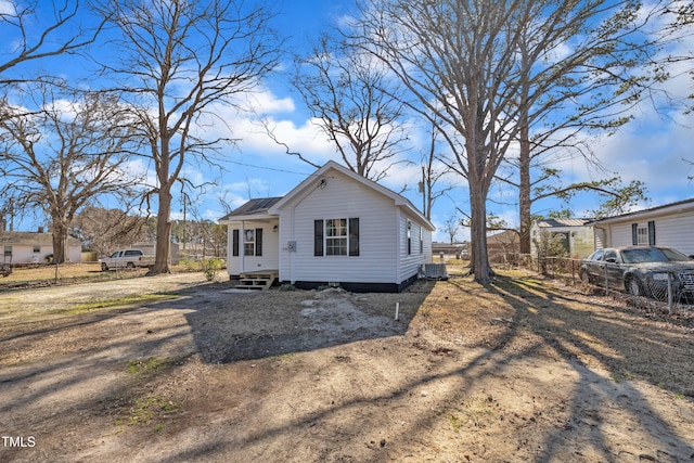 view of front of property with entry steps, central AC, and fence