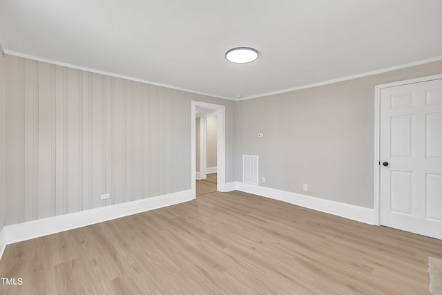 spare room with visible vents, crown molding, light wood-style flooring, and baseboards