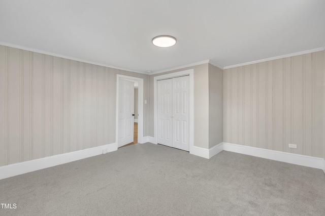 spare room with carpet floors, baseboards, and crown molding