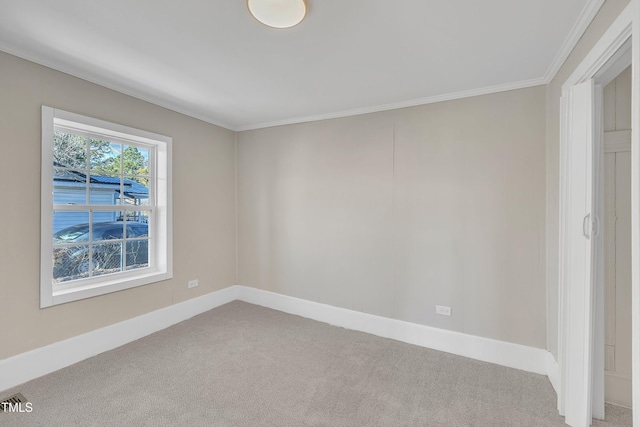 carpeted spare room with ornamental molding, visible vents, and baseboards