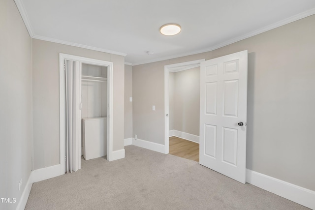 unfurnished bedroom with light carpet, baseboards, ornamental molding, and a closet