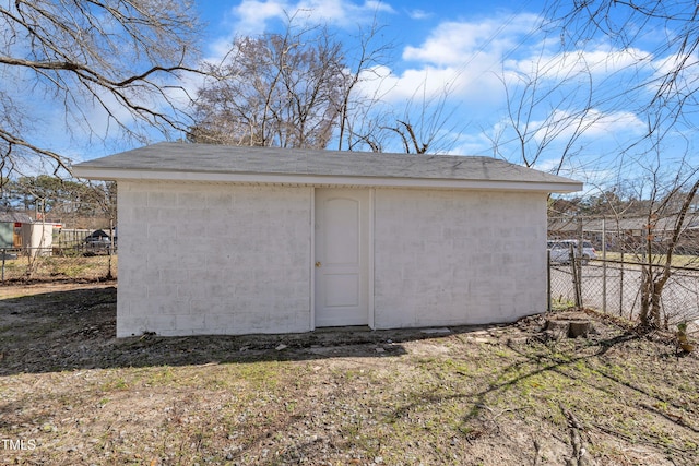 garage featuring a storage unit and fence