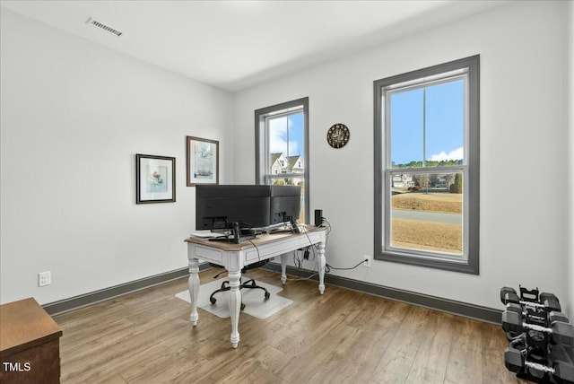 office space featuring visible vents, baseboards, and wood finished floors