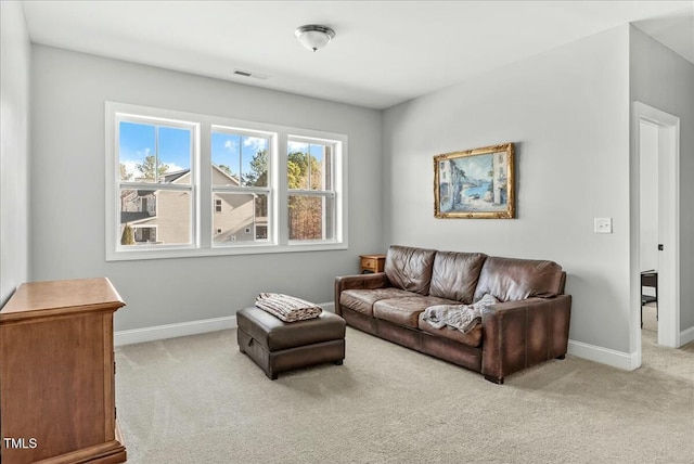 carpeted living area featuring visible vents and baseboards