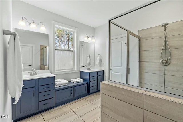 full bath featuring a stall shower, two vanities, and a sink