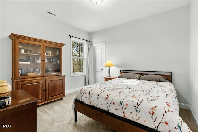 bedroom featuring baseboards, visible vents, and light colored carpet